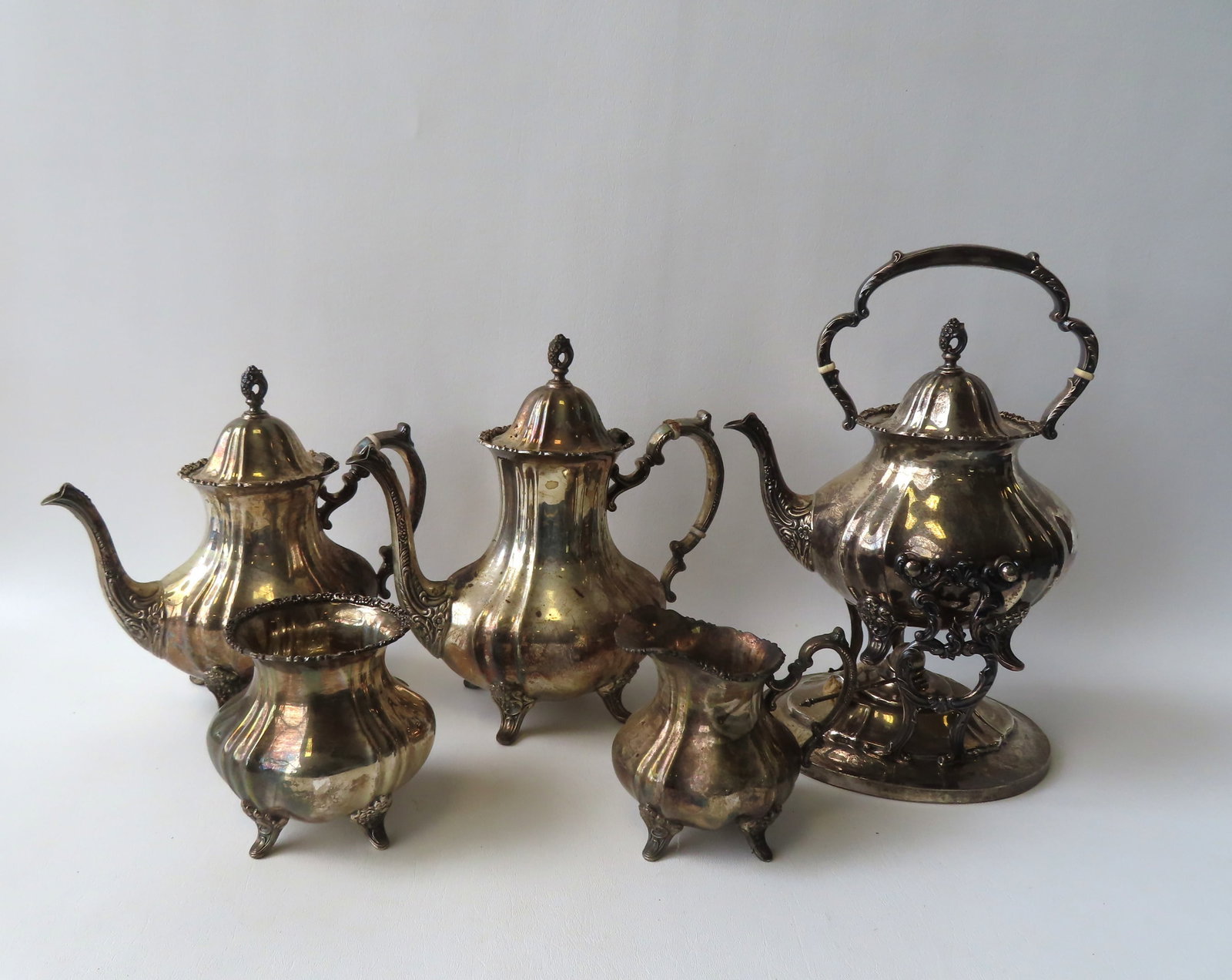A five piece sterling silver tea service consisting of a coffee pot, teapot, hot water kettle on: A five piece sterling silver tea service consisting of a coffee pot, teapot, hot water kettle on stand with heater, and a sugar and creamer - probably early 20th century (see photo of hallmark on base