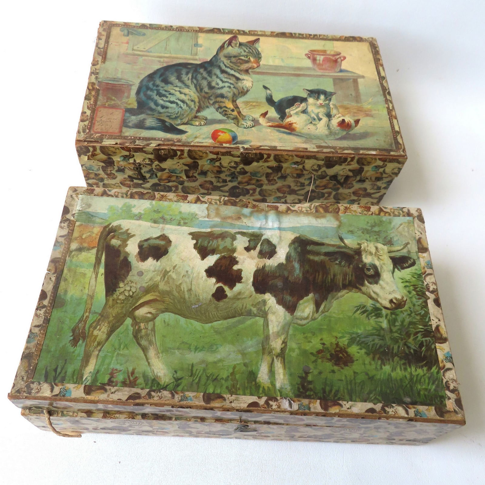 Two lithographed block puzzle sets, each with 6 large blocks with interior pull-string bellows that: Two lithographed block puzzle sets, each with 6 large blocks with interior pull-string bellows that make animal noises when pulled. The box with cow cover is missing the string on one block, missing t