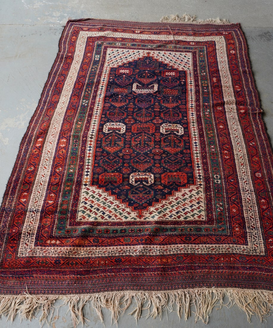 An early oriental tribal rug having a woven ends with long fringe (some losses to fringe on one end): An early oriental tribal rug having a woven ends with long fringe (some losses to fringe on one end) - remainder of rug is hand knotted. The rug with 2 areas of where wool has loosened leaving lines i