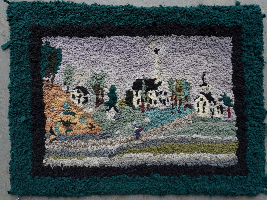 A small free-hand pictorial hooked rug depicting a figure walking on path near a small house and 2: A small free-hand pictorial hooked rug depicting a figure walking on path near a small house and 2 steepled churches, late 19th century. Several loose wool thread around border, otherwise very good co