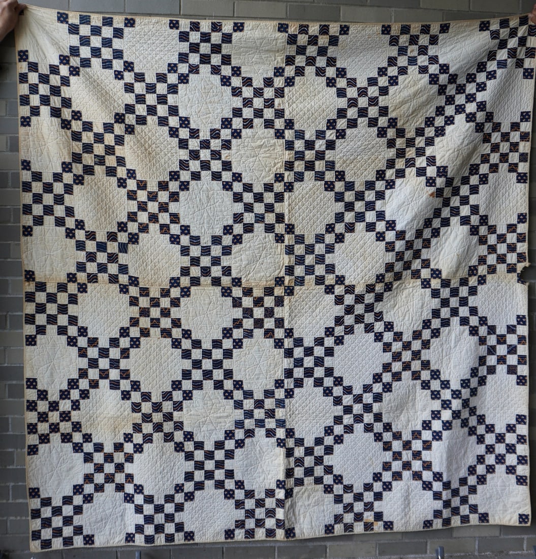 A patchwork quilt, Double Irish Chain pattern, 19th century. Very fine quilting, approximately 10-12: A patchwork quilt, Double Irish Chain pattern, 19th century. Very fine quilting, approximately 10-12 stitches per inch. Some staining, small chew mark loss at border, otherwise good condition. Measure