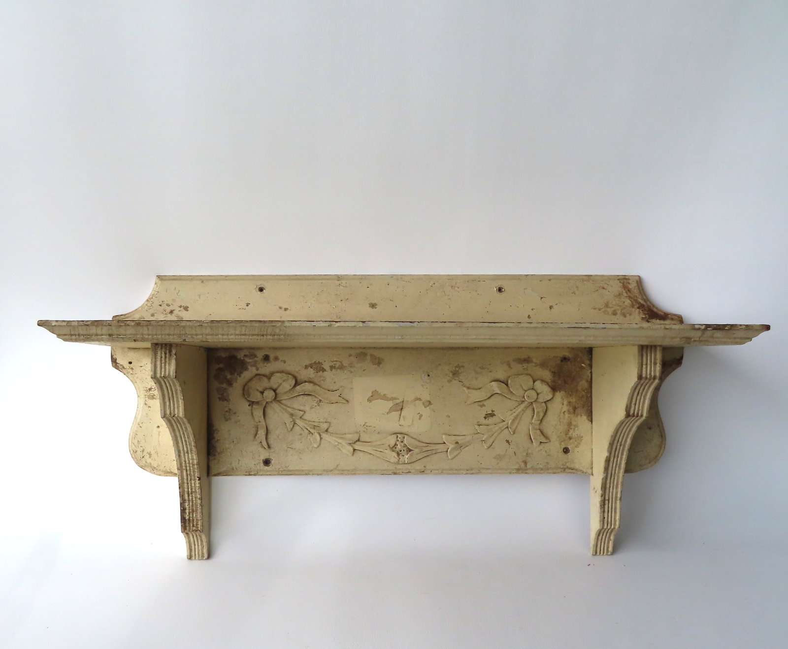 A country pine wall shelf in layers of old paint, late 19th century.: A country pine wall shelf in layers of old paint. The shelf with molded edge and with shaped backsplash and support brackets, 19th century, good condition but needs cleaning. Measures 30"W x 9"D x 15"