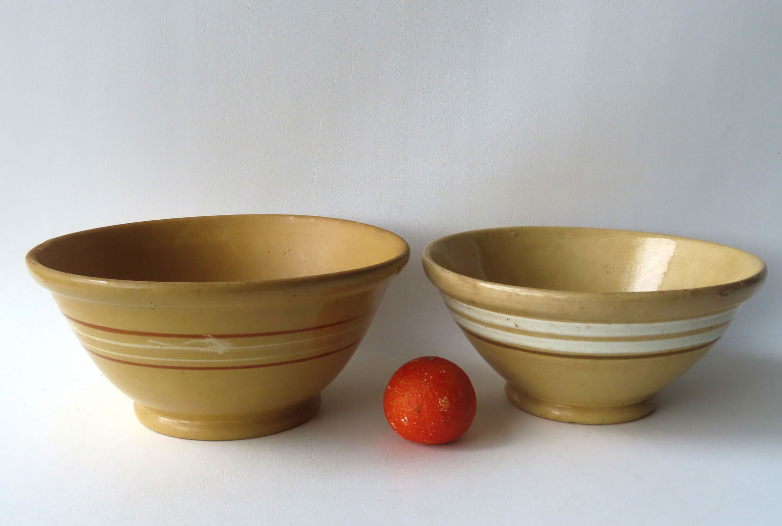 Two large banded yellowware mixing bowls with rolled rims on footed bases. The largest in very good (1 of 11)