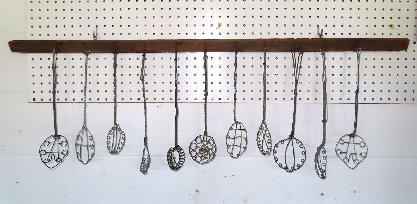 A grouping of 11 wire strainers, late 19th to early 20th century, mounted on a 19th century tobacco (1 of 6)