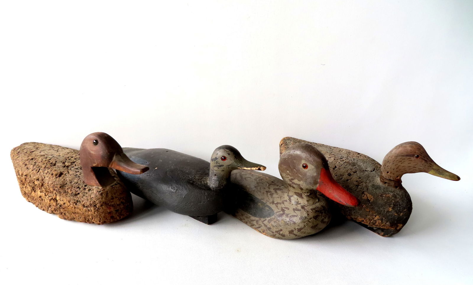 Grouping of 4 primitive decoys, late 19th to early 20th century, including: 2 cork Black Ducks with (1 of 12)
