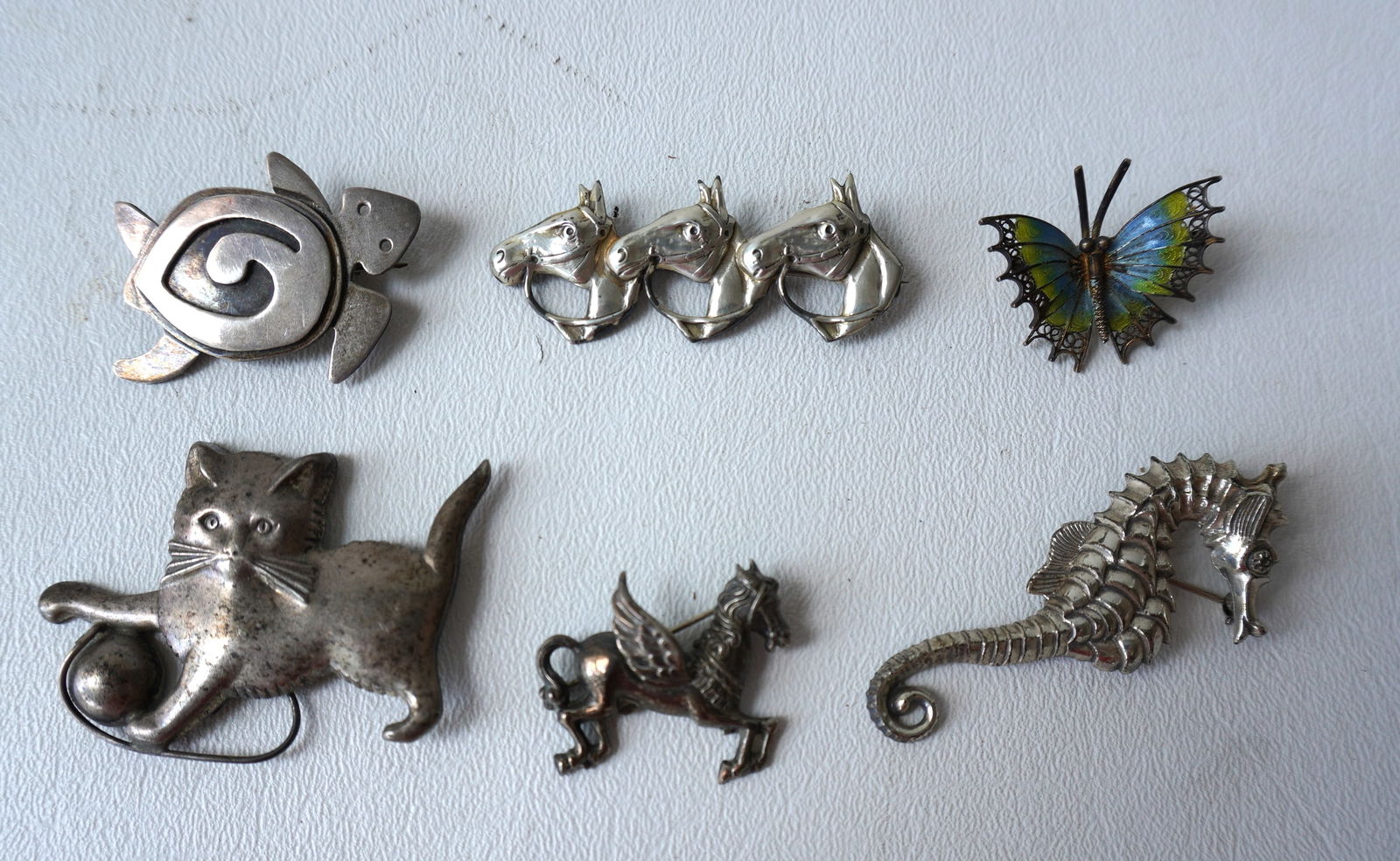 Six silver figural brooches, 5 in sterling and 1 in 800 silver.  Sterling pieces include a cat with (1 of 2)
