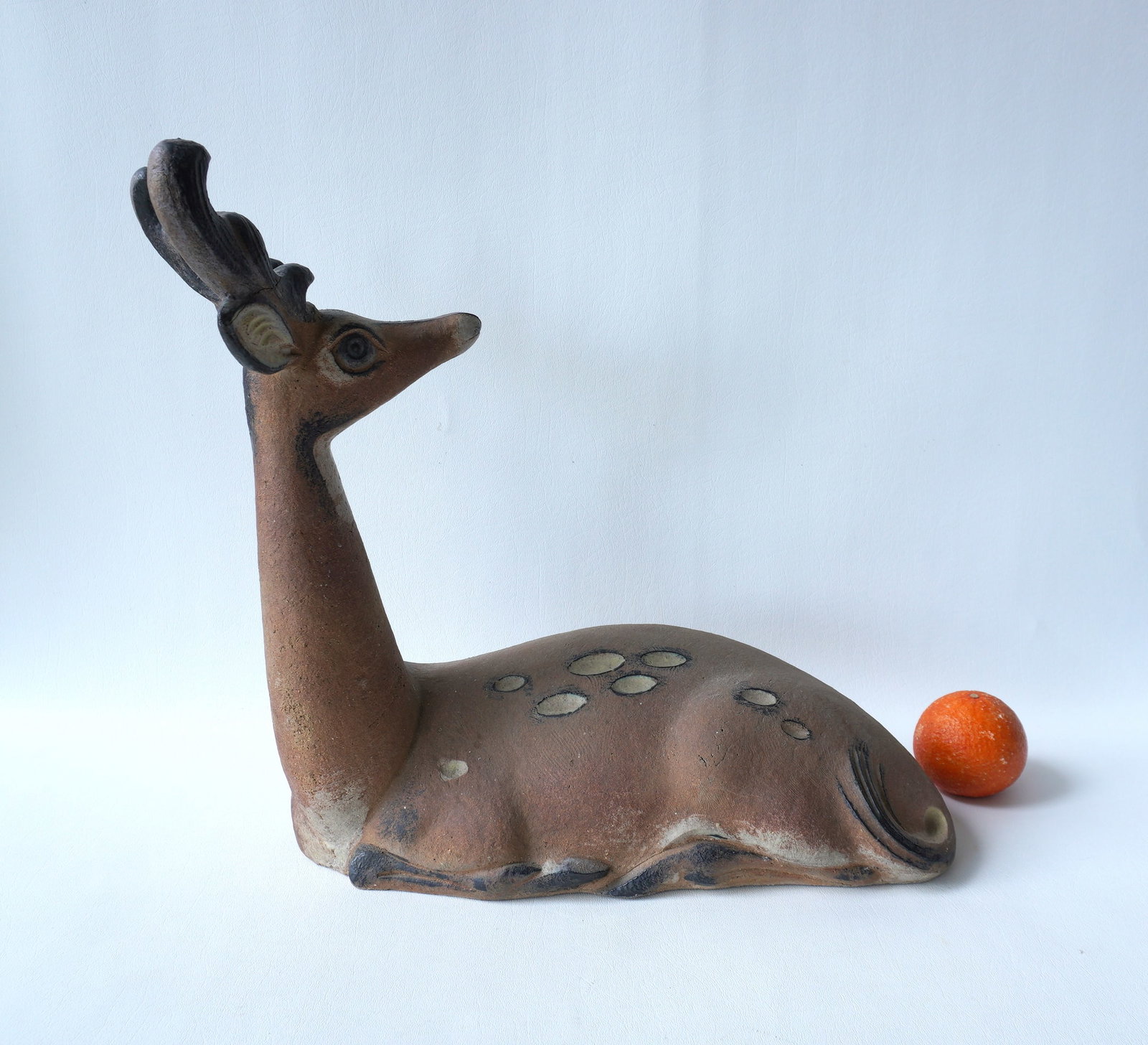 Walter Addison, New York, 1914-1982. A terra cotta resting stag garden sculpture, with hand painted: Walter Addison, New York, 1914-1982. A terra cotta resting stag garden sculpture, with hand painted highlights, signed Addison, probably mid 20th century. Measures 19"L x 8"W x 16 1/2"H. Very good con