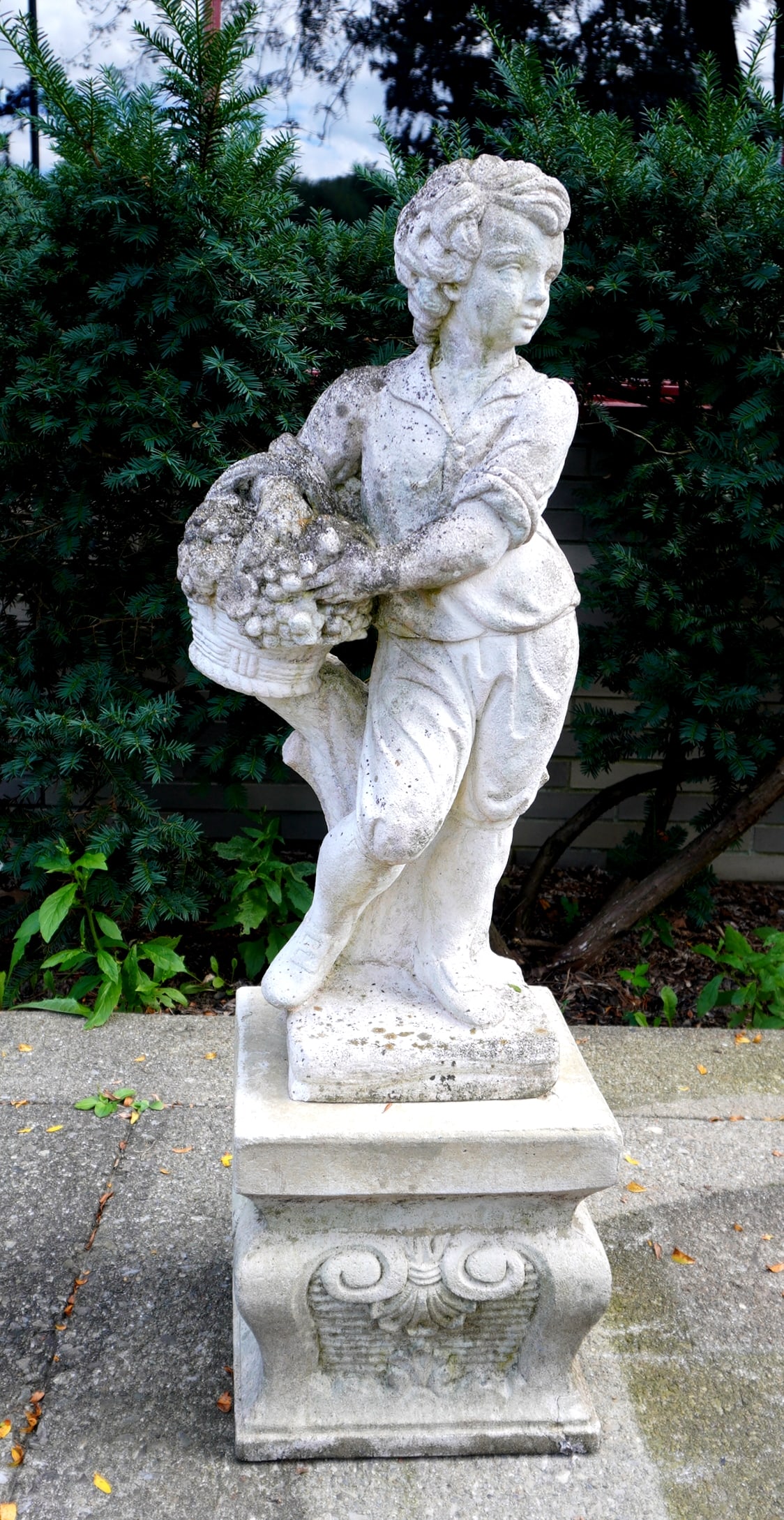 Cast stone garden statue of boy holding a basket of grapes, circa 1960-80. (1 of 11)