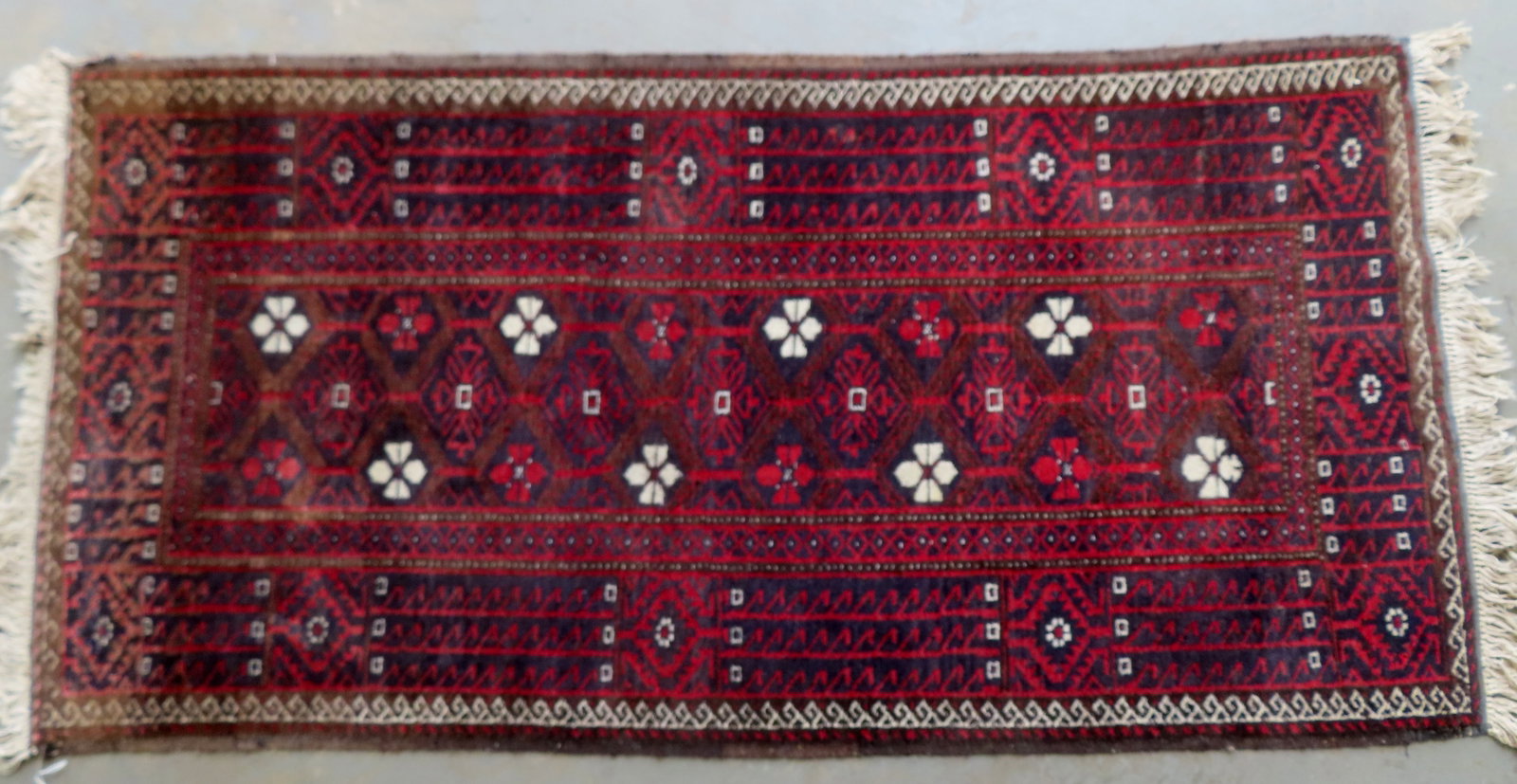 An oriental scatter rug with "Made in Iran" label.: An oriental scatter rug with "Made in Iran" label. Some use wear, but overall good condition. Measures 6' 1" x 3'.