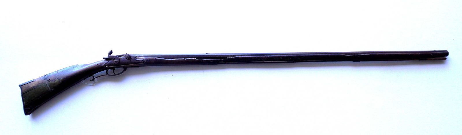 An early flintlock conversion rifle with octagonal barrel in tiger maple with losses and needing: An early flintlock conversion rifle with octagonal barrel in tiger maple with losses, non working, and needing restoration - see photos for further information. Barrel 45"L and overall 59"L. Early 19t