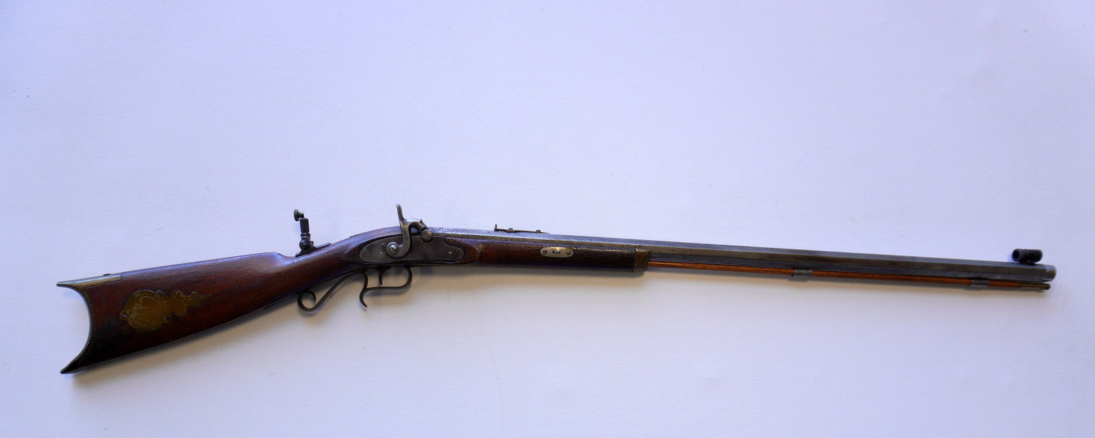 A modified 19th century percussion rifle with target rifle additions including newer peep sight. The: A modified 19th century percussion rifle with target rifle additions including newer peep sight. The rifle having an octagonal barrel, walnut stock, brass patch box and butt plate. Working action, som