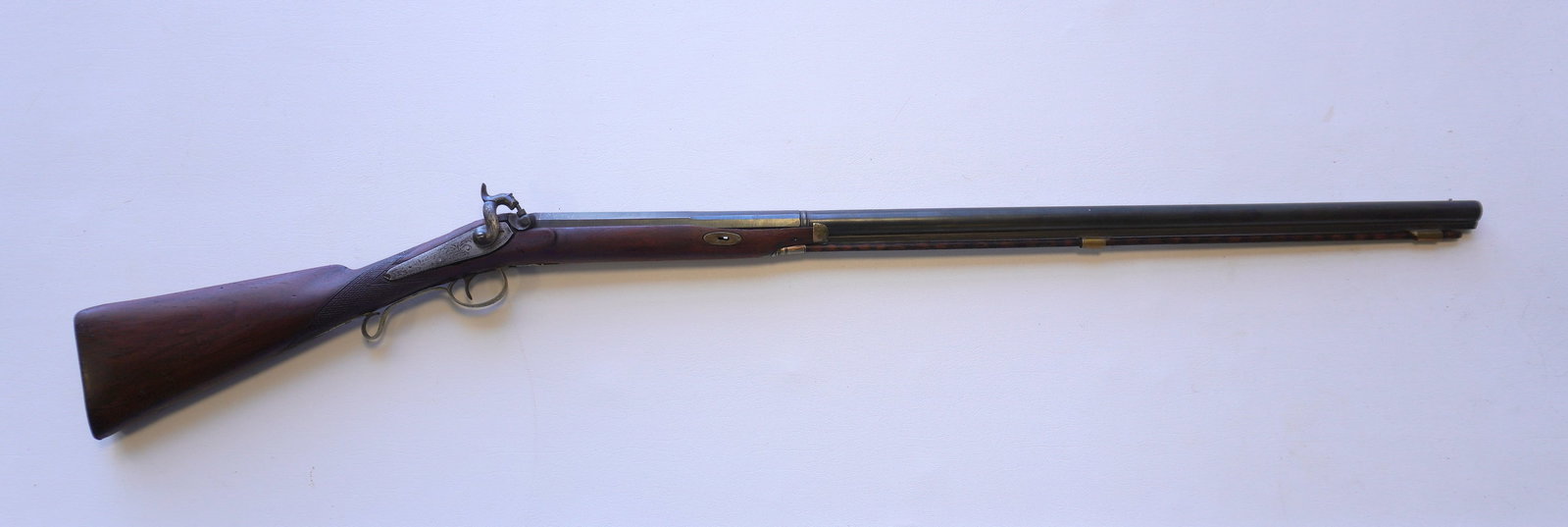Percussion rifle with partially checkered stock, engraved action, signed illegibly by maker, and: Percussion rifle with partially checkered stock, engraved action, signed illegibly by maker, and having a partial octagonal barrel marked "Twist" and initialed W.K. - non-working action, repairs to st