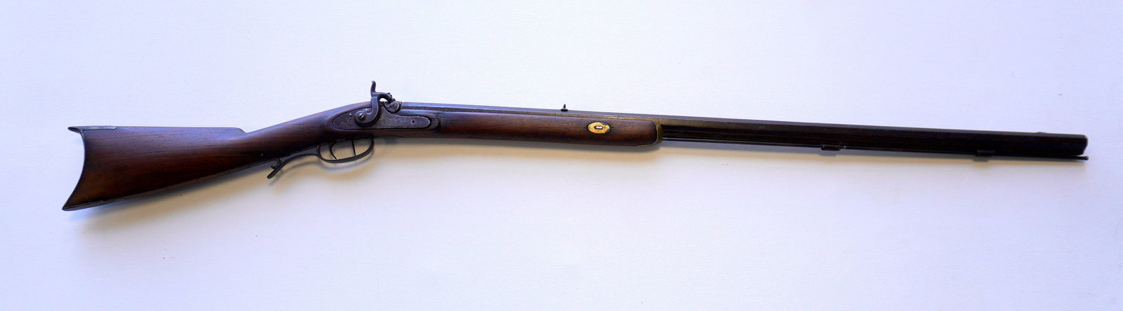 Percussion sporting rifle with octagonal barrel with set trigger. Working action, heavy use wear to: Percussion sporting rifle with octagonal barrel with set trigger. Working action, heavy use wear to action area, overall fair condition. Barrel 34 1/4"L and overall 50 3/4"L. Provenance: From a local 