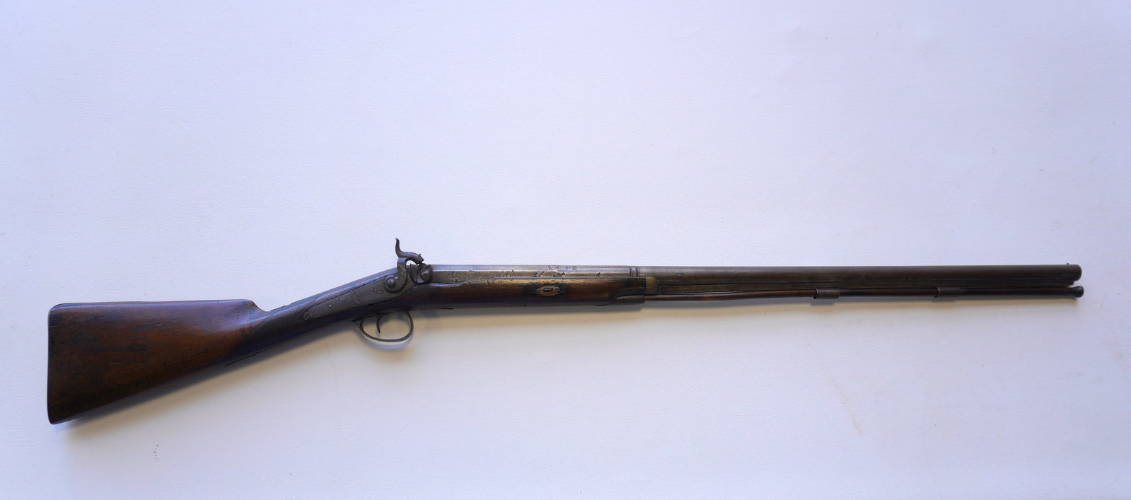 Single barrel shotgun with worn signature on top of barrel, engraved lock plate, partial checkered: Single barrel shotgun with worn signature on top of barrel, engraved lock plate, partial checkered walnut stock, steel butt plate, partial octagonal barrel, and original ram rod. Working action, small