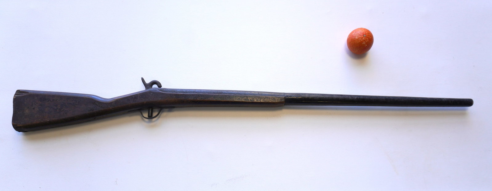 A parade or practice rifle in original crusty paint, probably Civil War era: A hand carved wooden parade or practice rifle in original crusty paint, probably Civil War era, missing butt plate otherwise good original condition. Iron hardware attached similar to a percussion rif
