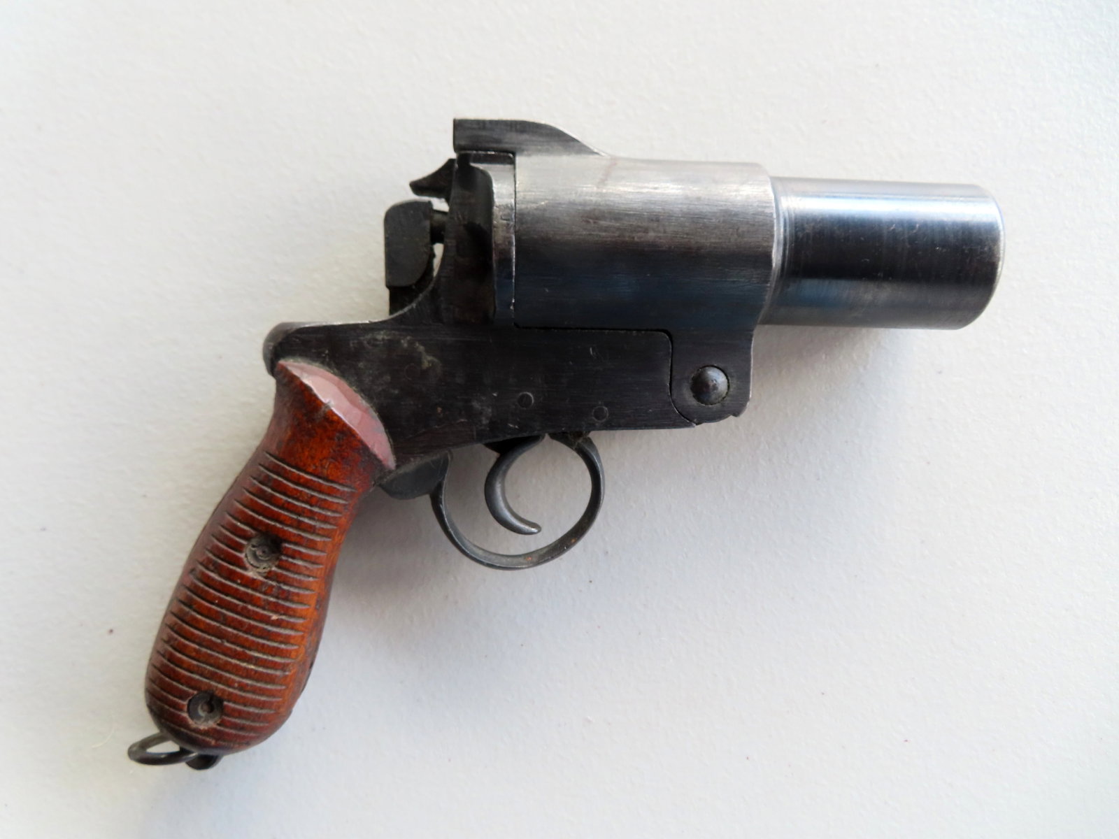 WWII Japanese Type 10 flare pistol with wooden handles.: WWII Japanese Type 10 flare pistol with wooden handles decorated with grooved horizontal lines and lanyard ring at bottom of grips - serial number 8198.Condition: The locking mechanism appears worn an