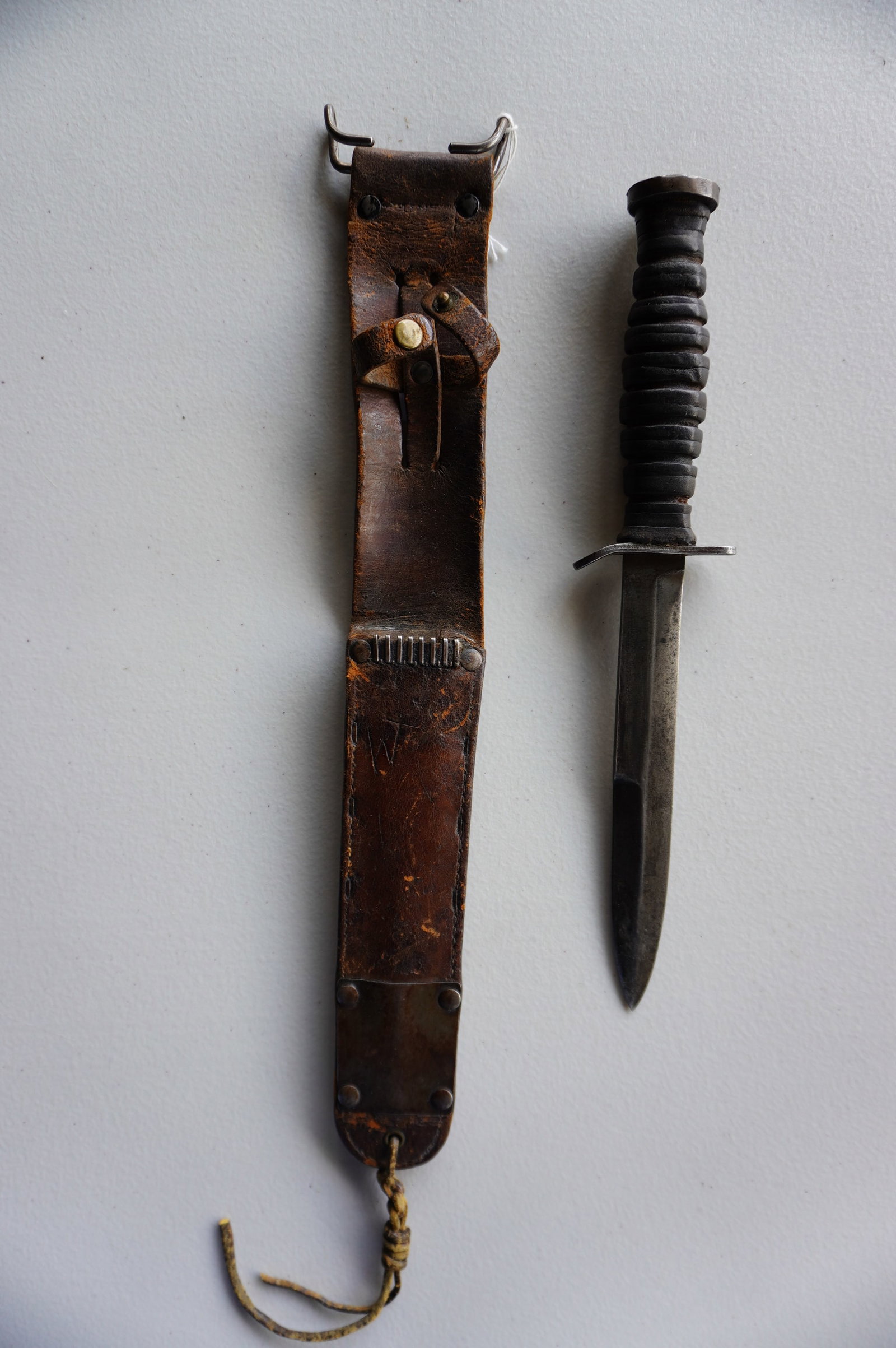 U.S. WWII fighting knife with original leather and brass sheath, marked on blade "U.S. M3 PAL: U.S. WWII fighting knife with original leather and brass sheath, marked on blade "U.S. M3 PAL 1943" - the knife in very good condition - the scabbard with use wear and scratched initials "WT", otherwi