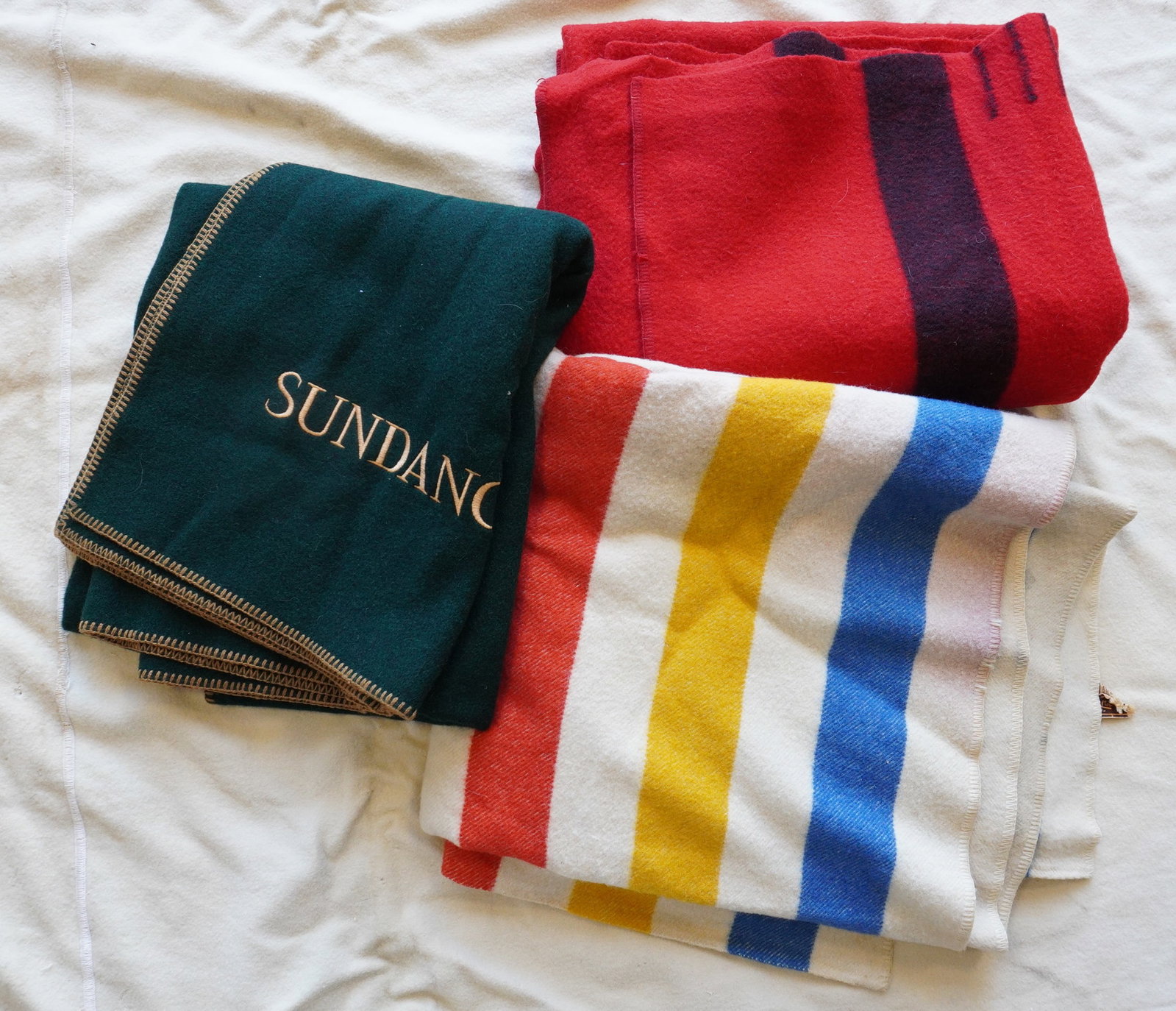 Three trapper style wool blankets including "Horner All Virgin Wool" - 86" x 73" - some stains: Three trapper style wool blankets including "Horner All Virgin Wool" - 86" x 73" - some stains including slight running of the red color; the red trapper blanket missing label - 81" x 68" - some pet h
