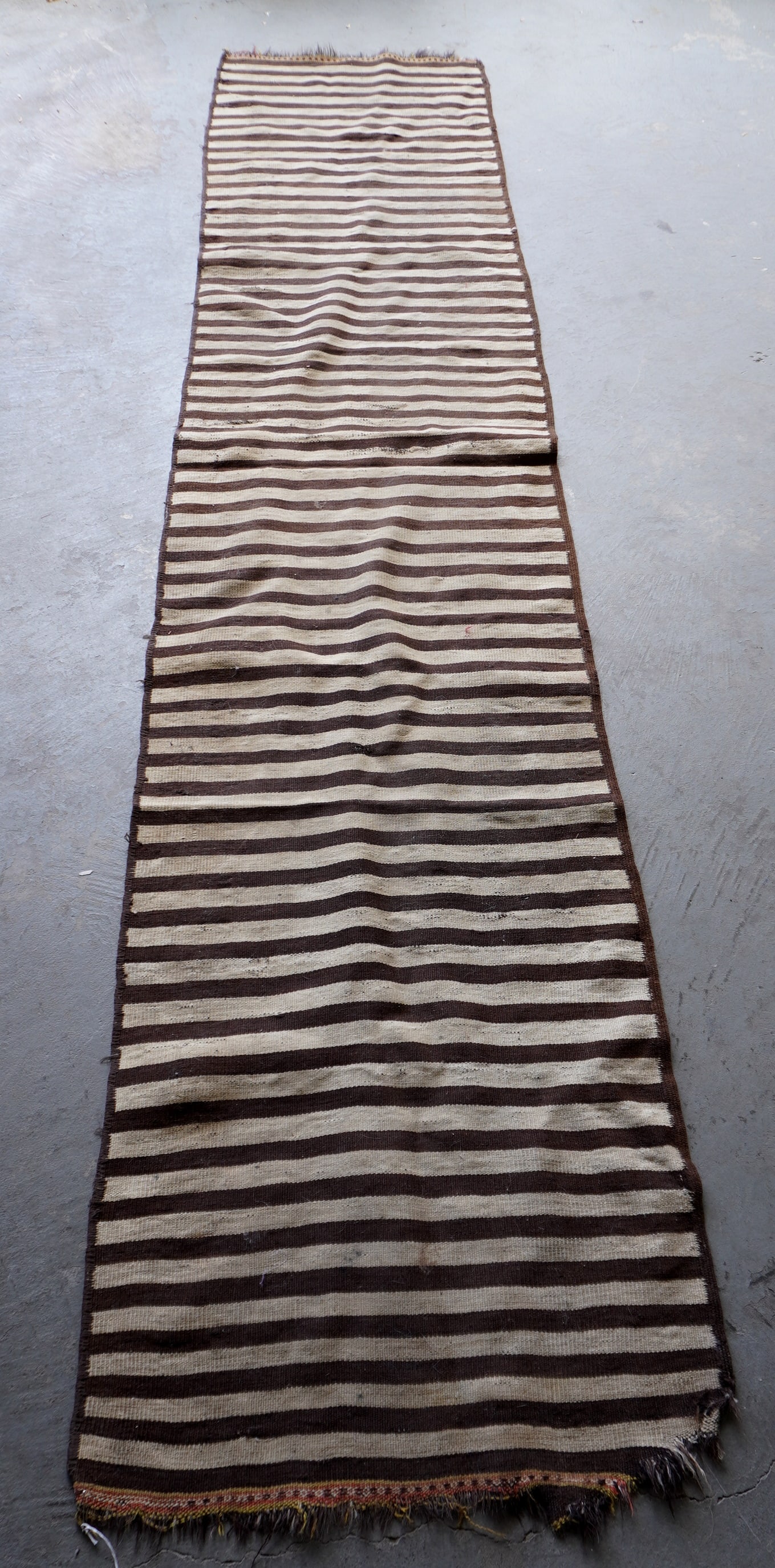 A long vintage tribal Kilim runner, hand woven, circa 1920. Needs cleaning and losses on one end.: A long vintage tribal Kilim runner, hand woven, circa 1920. Needs cleaning and losses on one end. Measures 10' 9"L x 2' 3 1/2"W.