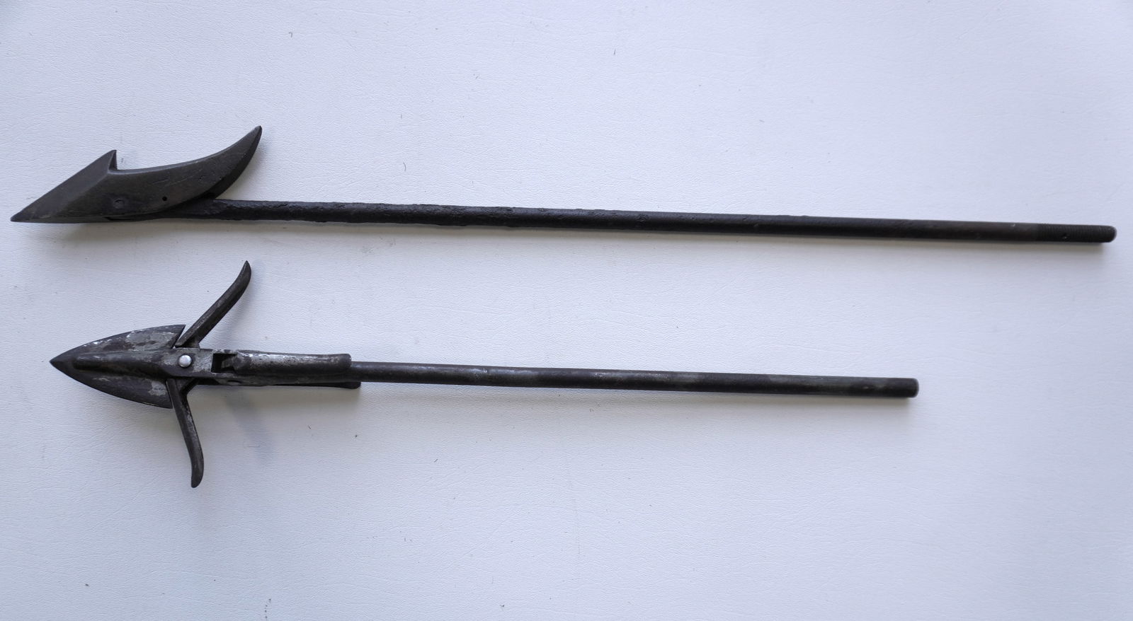 Two wrought iron whaling harpoons including: The first, an iron whaling gun toggle harpoon, probably: Two wrought iron whaling harpoons including: The first, an iron whaling gun toggle harpoon, probably late 19th to early 20th century; and a single flued iron harpoon with a pitted iron shaft and bronz