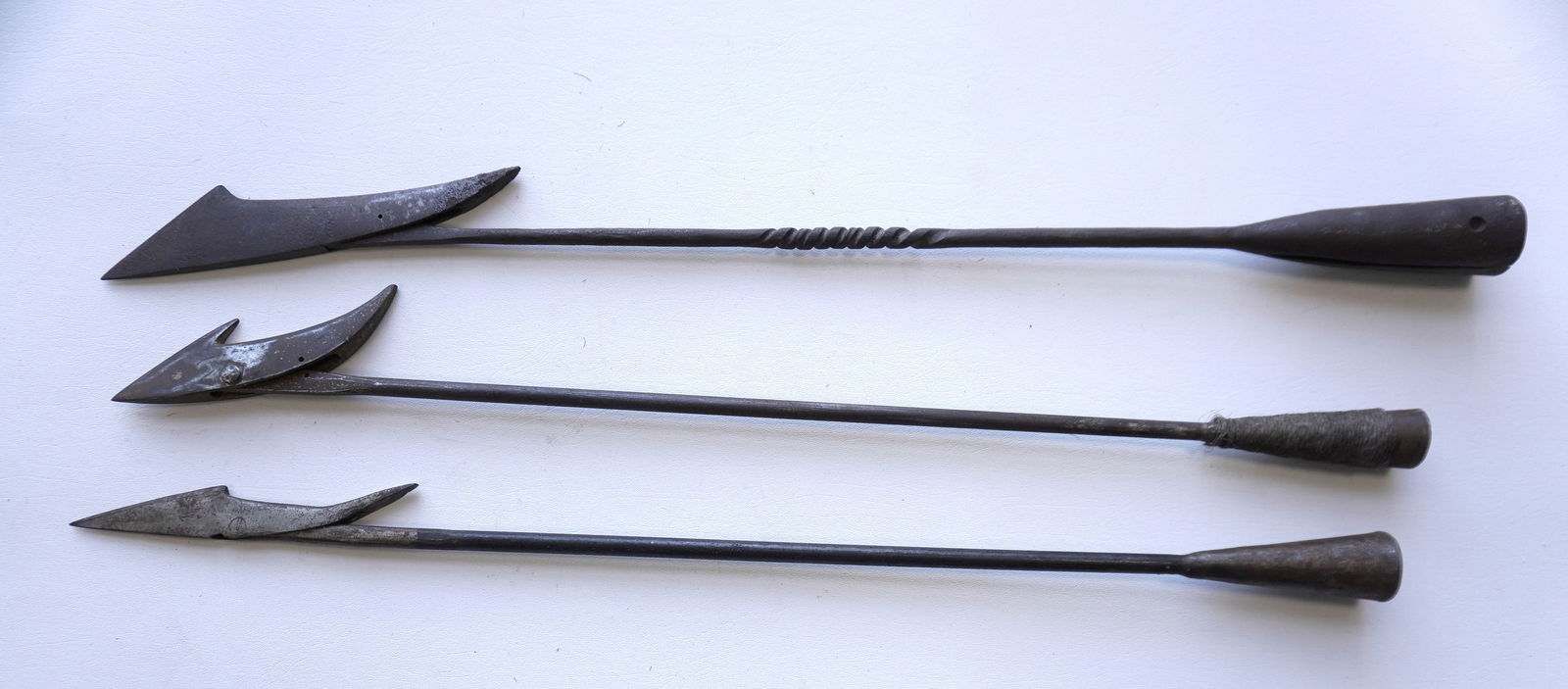 Three iron whaling harpoons, 2 wrought iron and 1 hand forged. Early to mid 20th century. The: Three iron whaling harpoons, 2 wrought iron and 1 hand forged. Early to mid 20th century. The largest measures 33 1/2"L. Provenance: From the estate of Jeff Raymond, Red Hook NY.