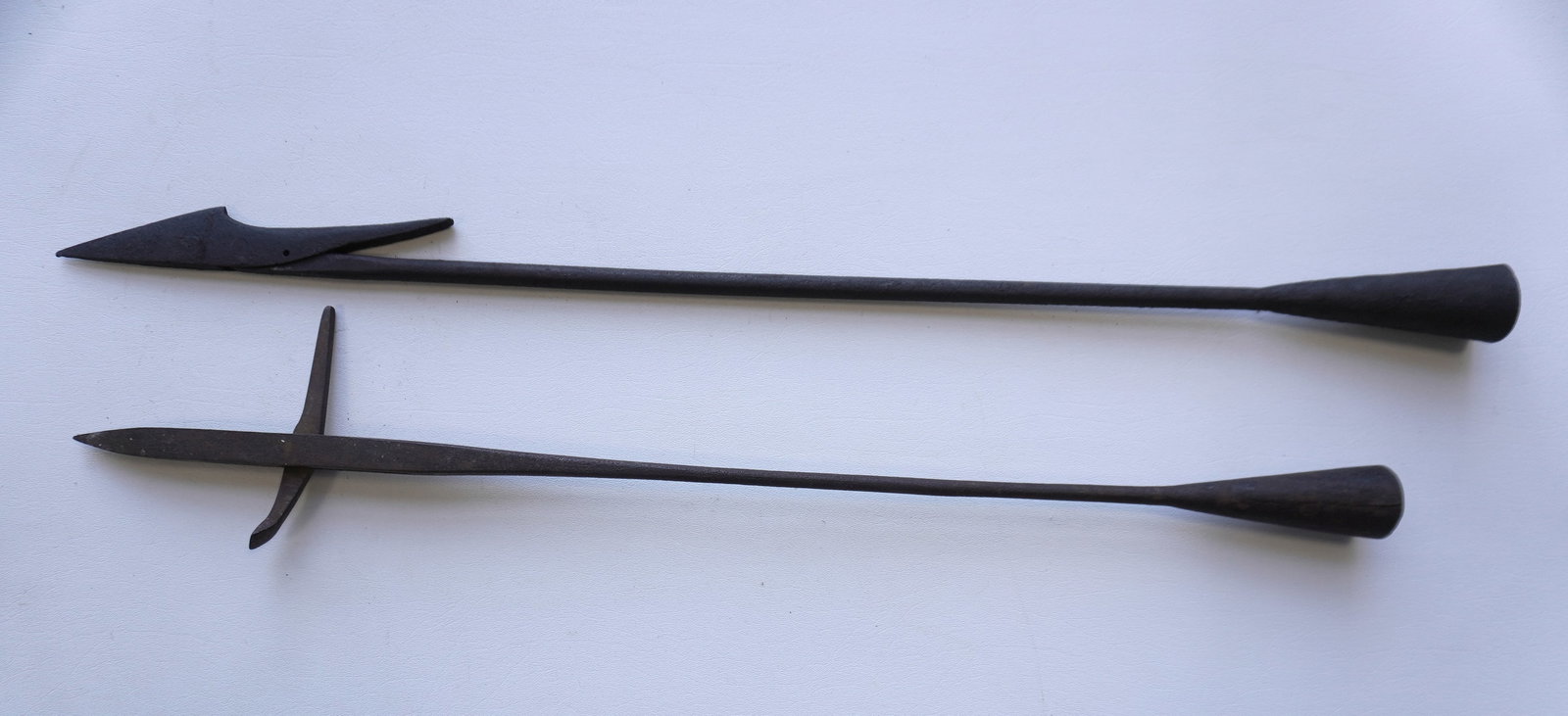 Two iron harpoons, 19th century. The single flued head harpoon with pitting and rust and the point: Two iron harpoons, 19th century. The single flued head harpoon with pitting and rust and the point does not move, the other in good condition. The largest measures 31"L. Provenance: From the estate of