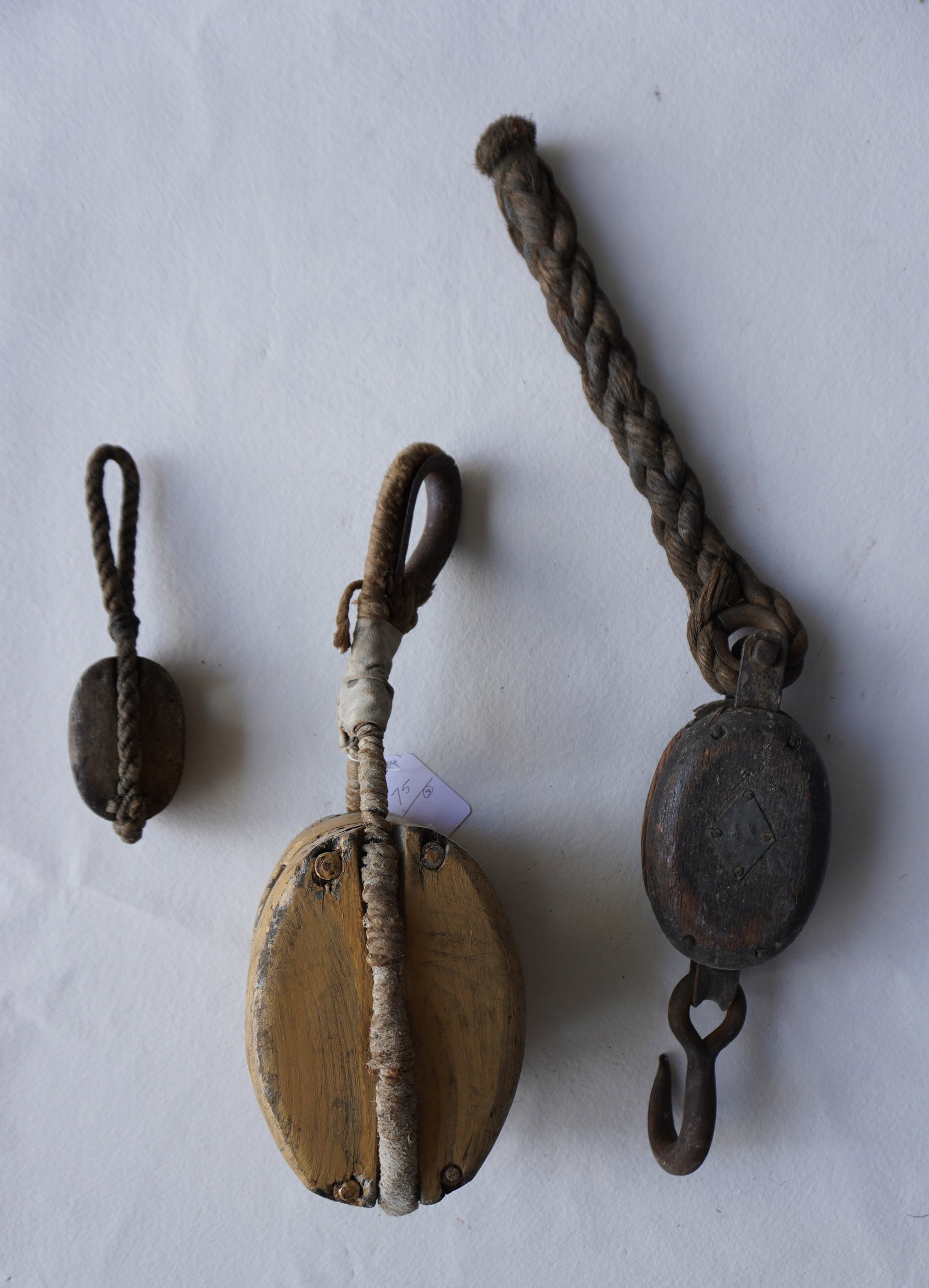 Two early wooden block and tackles with original sailor hand woven rope attached to each piece,: Two early wooden block and tackles with original sailor hand woven rope attached to each piece, including one in old yellow paint and the smallest with traces of original green paint. The largest, the