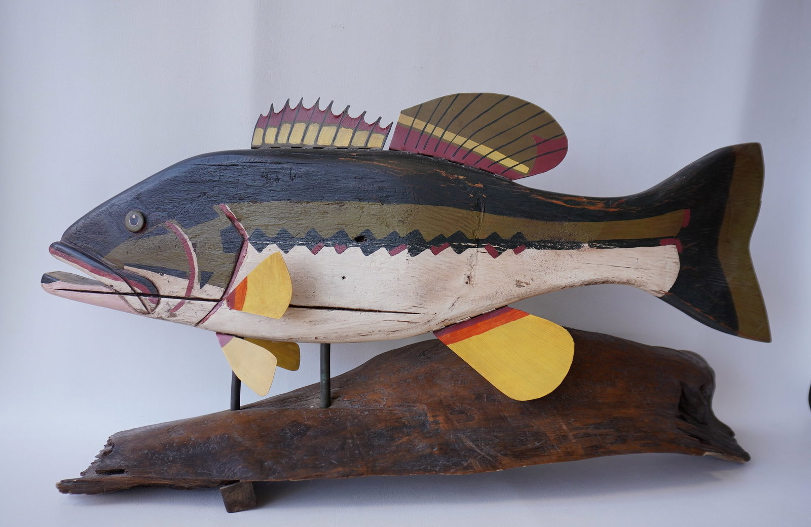 Jeff Raymond, folk art fish carving (1949-2022, Poughkeepsie and Red Hook NY). A fish carving: Jeff Raymond, folk art fish carving (1949-2022, Poughkeepsie and Red Hook NY). A fish carving depicting a bass mounted on a driftwood stand, signed "Raymond '94". Very good condition in original Paint
