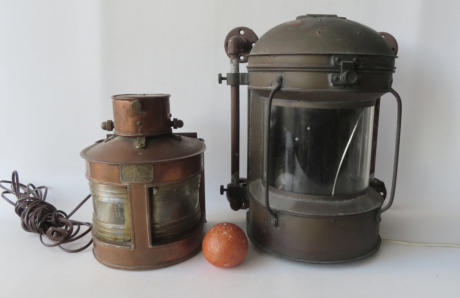 Two nautical lamps, electrified. The smaller in brass with rounded front having 2 colorless lenses -: Two nautical lamps, electrified. The smaller in brass with rounded front having 2 colorless lenses - one lens with loss in upper right corner - signed "Telford, Grier, Mackey & Co. Ltd Glasgow - also 