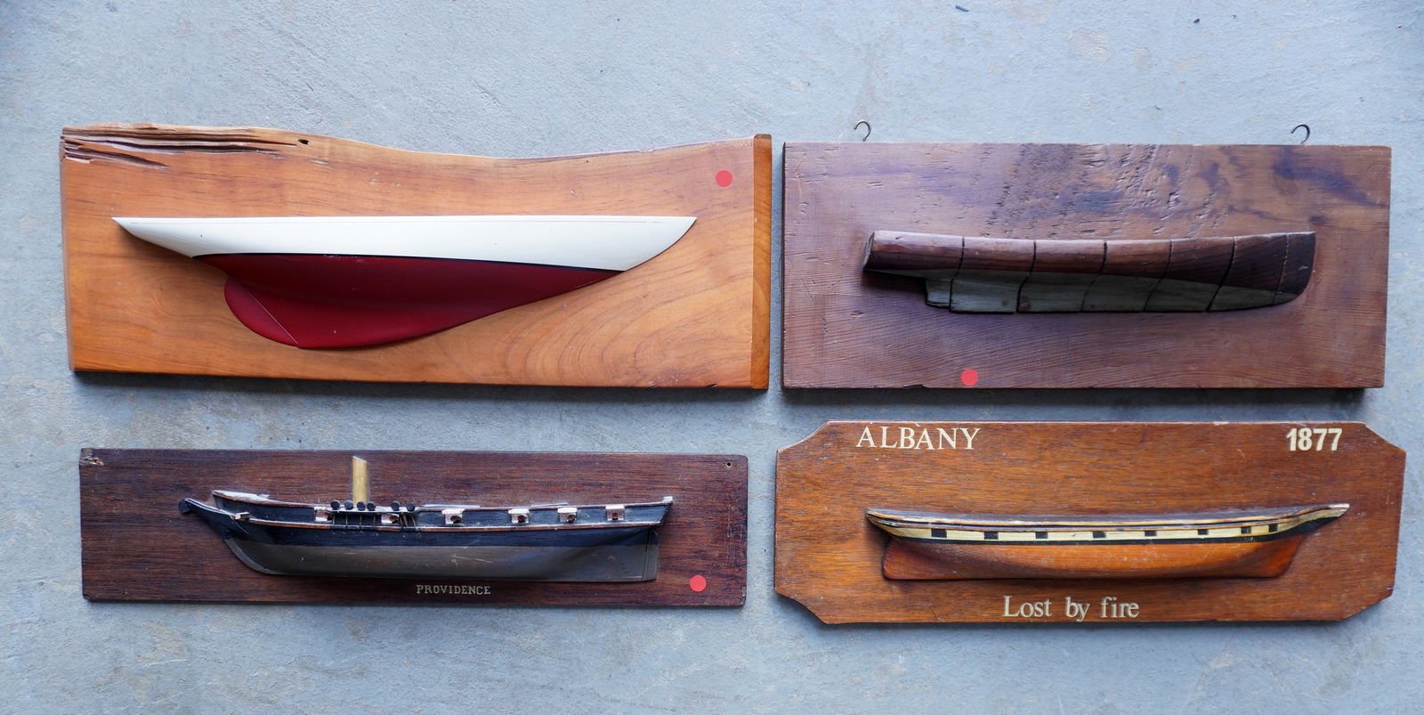 Four 1/2 hull ship models, 3 in carved wood, and the sailing vessel in composition, unknown carvers: Four 1/2 hull ship models, 3 in carved wood, and the sailing vessel in composition, unknown carvers - all in original finish and in very good condition, mid to late 20th century. The largest 22"L x 7