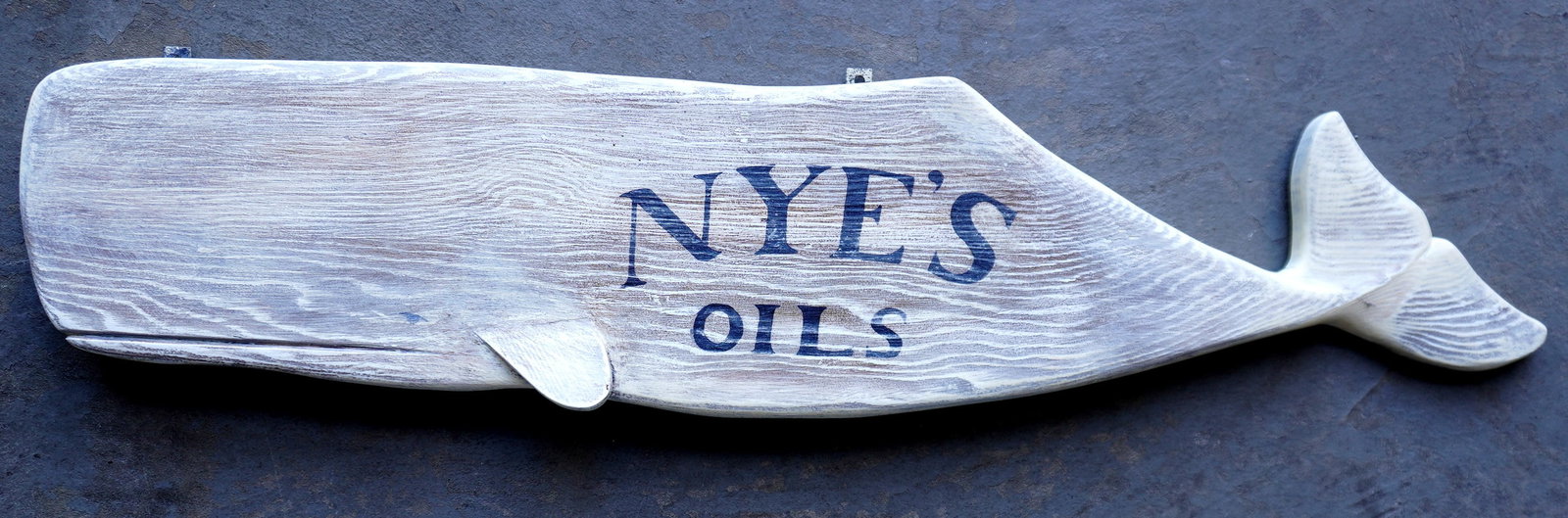 Contemporary Sperm Whale advertising sign marked "NYE'S OILS" - very good condition, circa 21st: Contemporary Sperm Whale advertising sign marked "NYE'S OILS" - very good condition, circa 21st century. Unknown carver. Measures 36"L x 8"H x 1 1/2" thick. Provenance: From the estate of Jeff Raymond