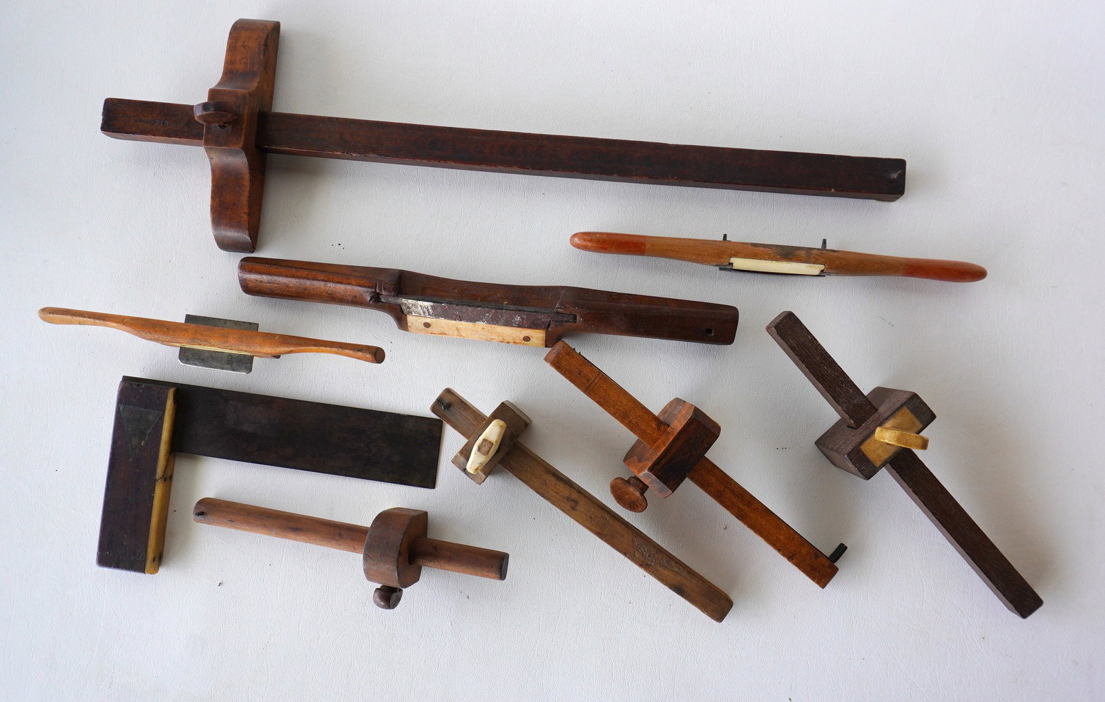 Grouping of 9 wooden carpenter's tools, each with an attached/imbedded small bone ornament, all 19th: Grouping of 9 wooden carpenter's tools, each with an attached/imbedded small bone ornament, all 19th century in good condition. Includes 3 spoke shaves, 5 scribes including one signed G.F. Savage, and