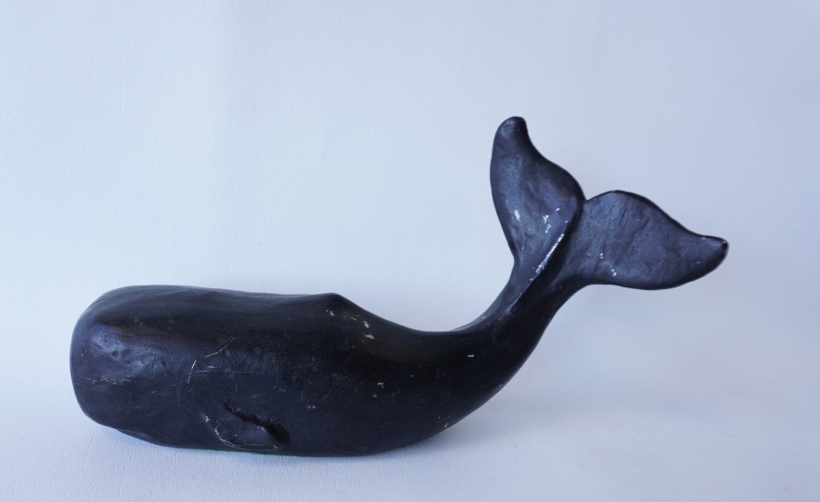 A cast metal sperm whale door stop in old black paint, circa 1900, very good condition. Measures: A cast metal sperm whale door stop in old black paint, circa 1900, very good condition. Measures 13"L x 7"H. Provenance: From the estate of Jeff Raymond, Red Hook NY.