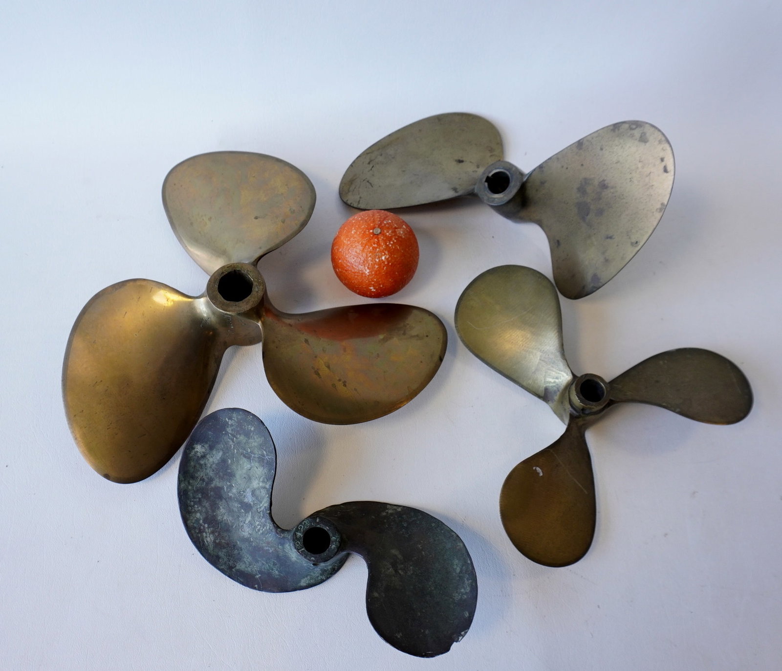 Four brass boat propellers, all in good condition. The largest measures 12" Diameter and signed "A K: Four brass boat propellers, all in good condition. The largest measures 12" Diameter and signed "A K / D14 P9 L" and another signed "Johnson Oakland Calif. USA.". All appear in good condition. Provena