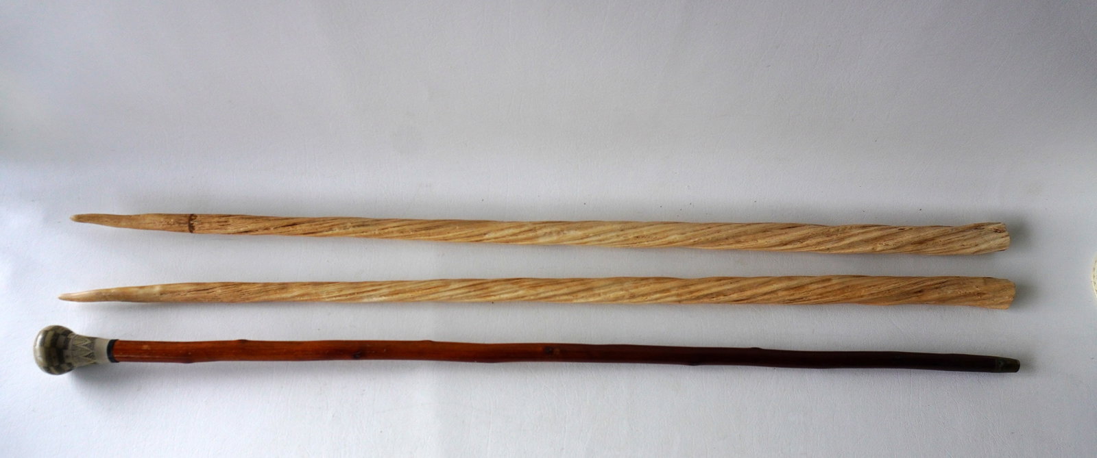 Two resin reproduction narwhal tusks - 36"L, and a reproduction walking stick with a resin scrimshaw: Two resin reproduction narwhal tusks - 36"L, and a reproduction walking stick with a resin scrimshaw knob handle - 36"L. All in very good condition, late 20th century. Provenance: From the estate of J