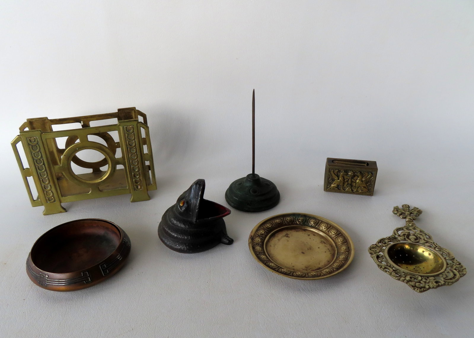 Grouping of decorative collectibles including: An ornate brass tea strainer, probably Dutch 19th: Grouping of decorative collectibles including: An ornate brass tea strainer, probably Dutch 19th century - very good condition - 6 7/8"L; a whimsical white metal coiled snake desk article (or ash tray