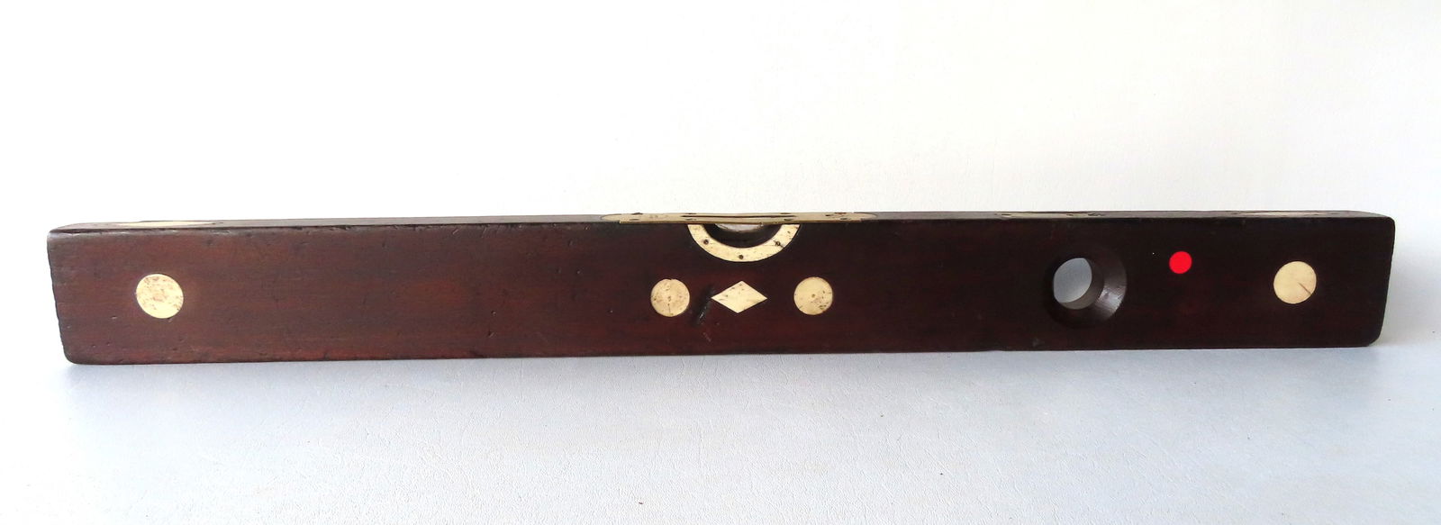 A wooden level with animal bone inlays signed Stanley - Rule & Level.: A wooden level with animal bone inlays signed Stanley - Rule & Level, patents 1862 & 187n. Some use wear, top level is broken and does not work, otherwise good condition. Measures 29 7/8"L x 3"H x 1 1