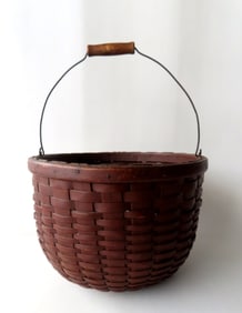 A splint wood apple basket with bale handle in original red paint, with a turned wooden base,  and