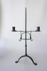 A hand forged adjustable double font Queen Ann lighting device with penny feet, 18th century.