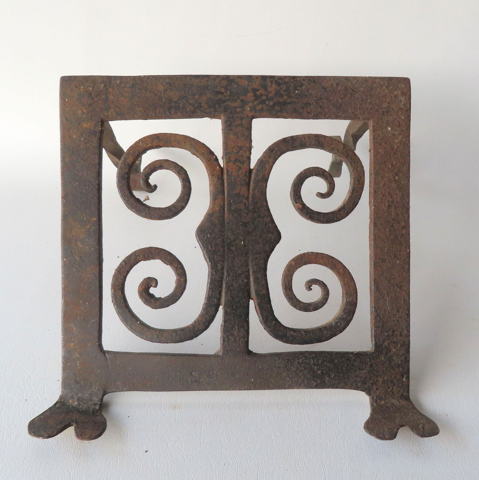 An unknown hand forged iron hearth item, possibly a trivet, with scrolled decorations on base, heavy (1 of 5)