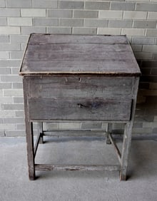 A primitive country store desk in original blue-green paint having a stretcher base, lift top with