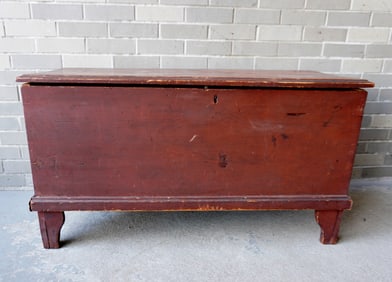 A blanket box in original red paint with molded edge to lid, on cutout base, interior till above