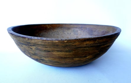 A treenware bowl with an unusual stepped molded rim, and scraped down to original mustard paint.
