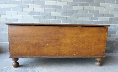 A good grain painted feed box in mustard color, on ball feet, original paint, and with 2 interior