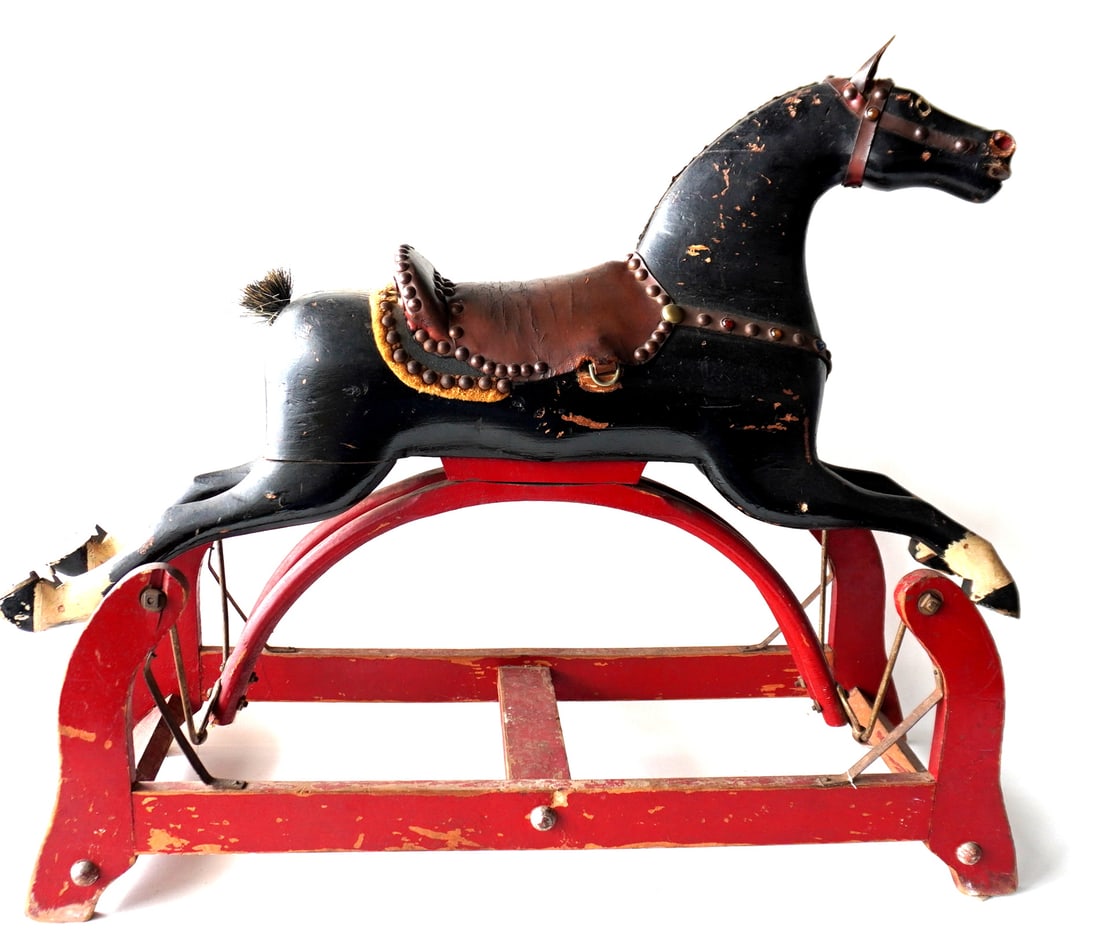 A good 19th century hobby horse with typical turned head and open mouth, in original black paint: A good 19th century hobby horse with typical turned head and open mouth, in original black paint mounted on platform in original red paint. Retains original tacked saddle and breast collar (missing st