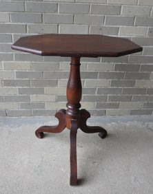 A cherry candlestand with octagonal top over turn pedestal leading to scrolled legs and feet, circa