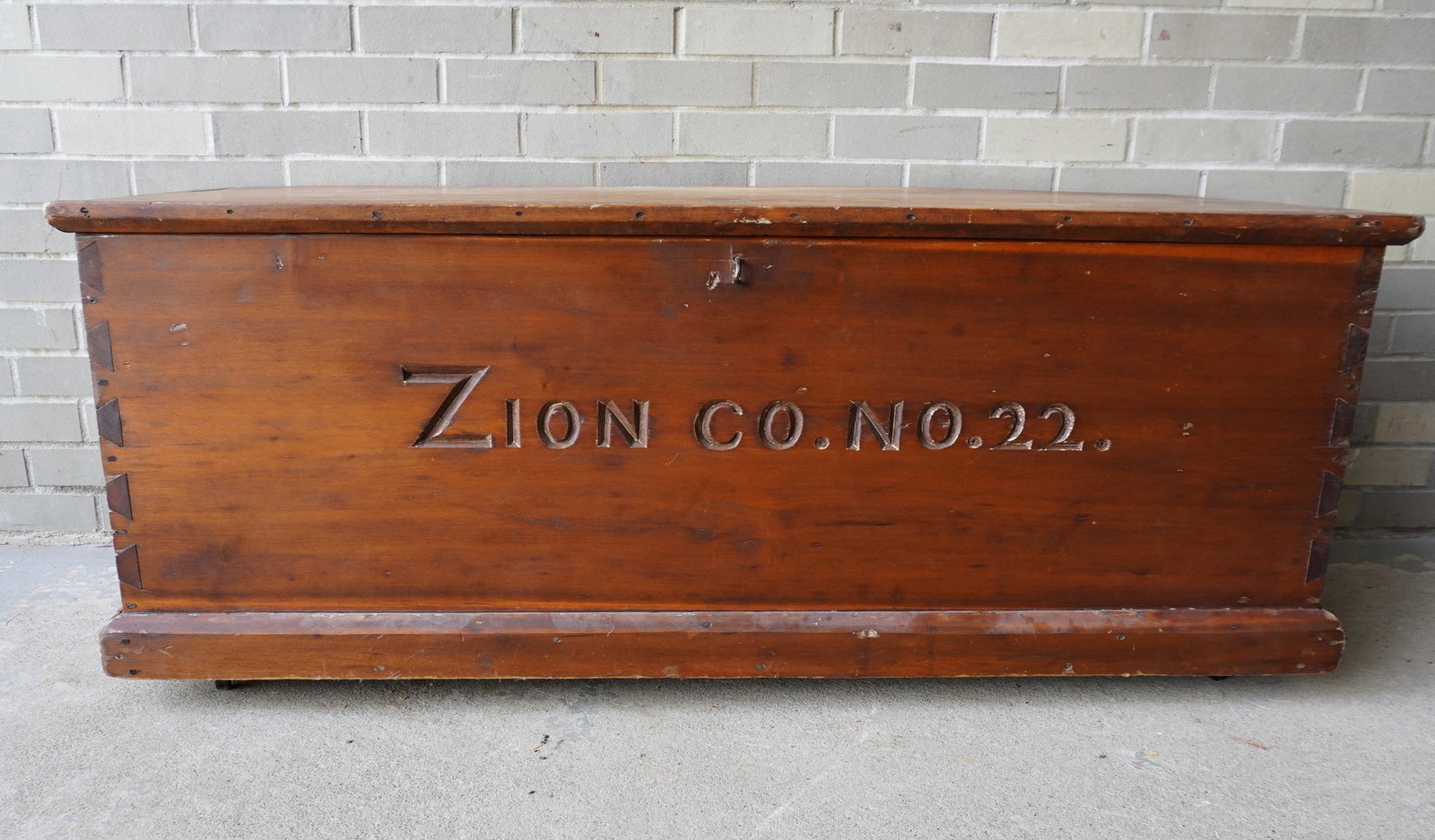 A blanket box with dovetailed sides and molded base, incised across the front "ZION CO. NO. 22.".: A blanket box with dovetailed sides and molded base, incised across the front "ZION CO. NO. 22.". The only reference we were able to find was a photograph from the Wappingers Historical Society with t