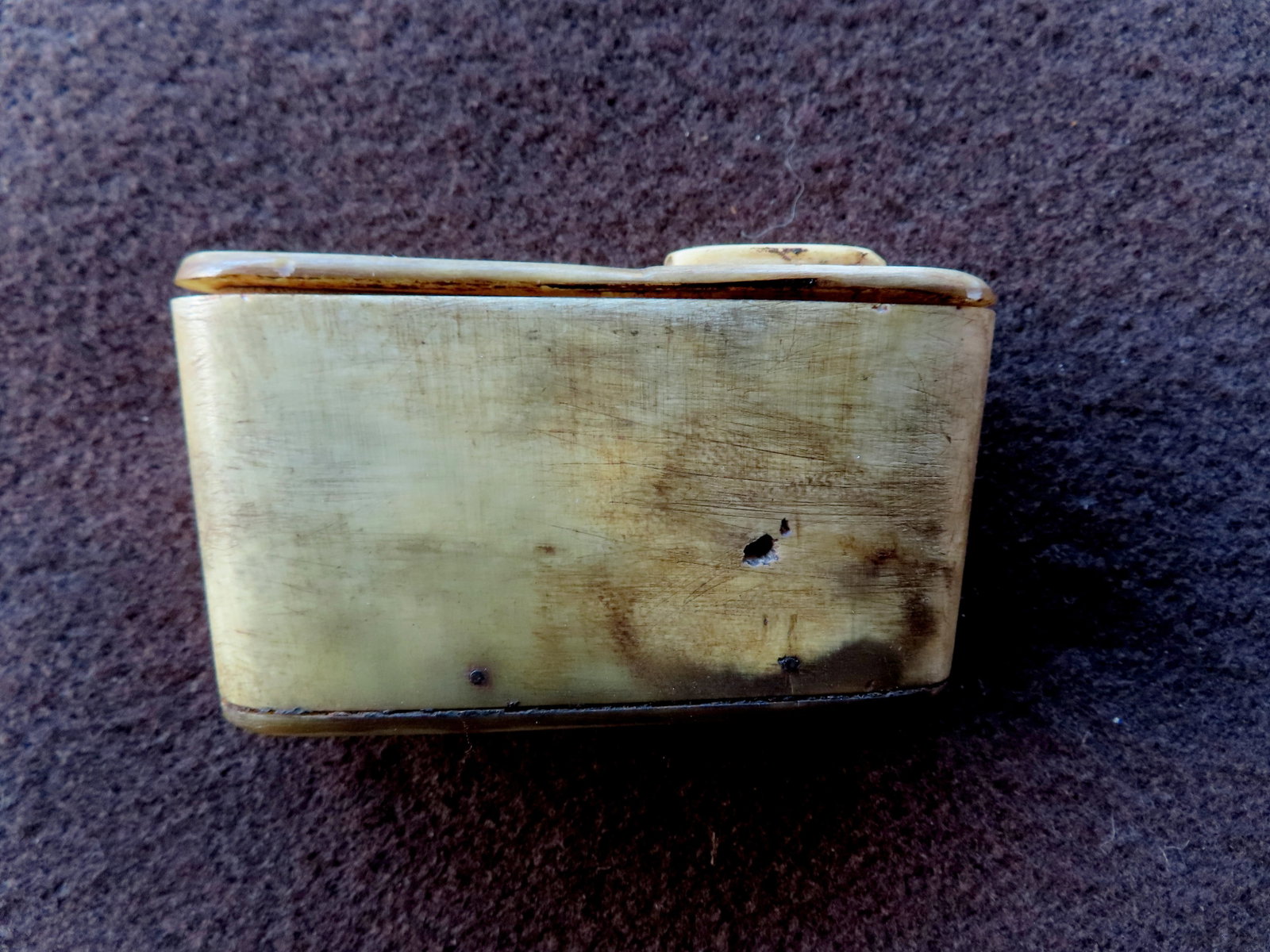 A cow horn covered box with opening at top with swivel cover, possibly for snuff or gun powder,: A cow horn covered box with opening at top with swivel cover, possibly for snuff or gun powder, early to mid 19th century. Good patina and use wear consistent with age and in good condition. Measures 