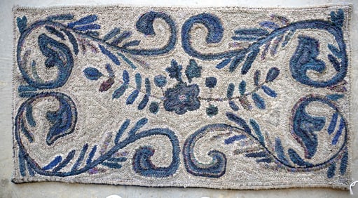 A hooked rug decorated in a flower and vine pattern, late 20th century. Measures 51" x 27".