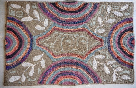 A hooked rug decorated in a rainbow and vine pattern, late 20th century. Measures 43" x 28".